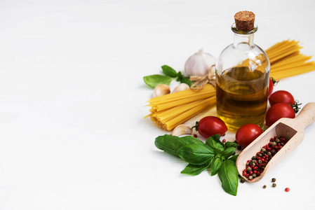 意大利食品配料橄榄油香料意大利面和西红柿在白色木制桌子上
