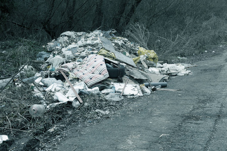 自然中的非法垃圾场. 污染森林小径附近的肮脏环境垃圾.