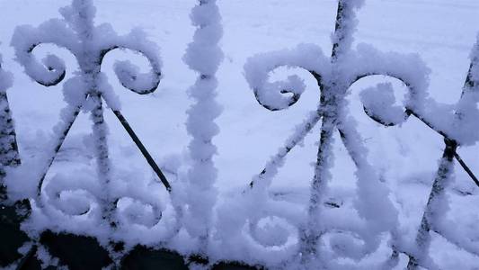 金属栅栏上的雪帽