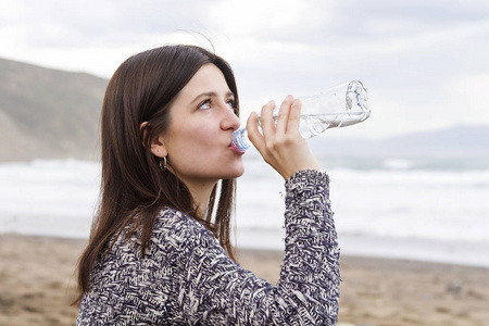 一个女孩从瓶子里喝淡水