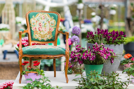 木制扶手椅，有漂亮的织物装潢和背景中的花朵。
