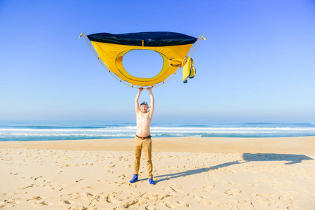 海滩之顶在葡萄牙大西洋附近的沙滩上顶着帐篷的裸体男子照片