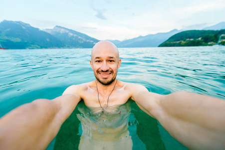 瑞士斯皮兹湖游泳时，秃头快乐男人自拍的镜头