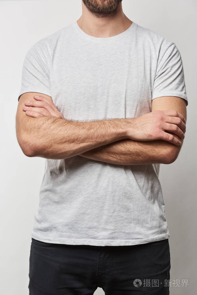 部分视角的人与手臂交叉在白色t恤与复制空间隔离在灰色