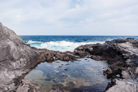 波浪在加那利群岛的岩石海岸破碎。 旅游旅游度假海上游轮。