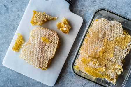 大理石板上有蜂蜜的新鲜蜂窝片。 有机食品。