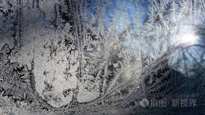 美丽的特写镜头冬季窗窗包覆盖闪亮的冰霜图案.