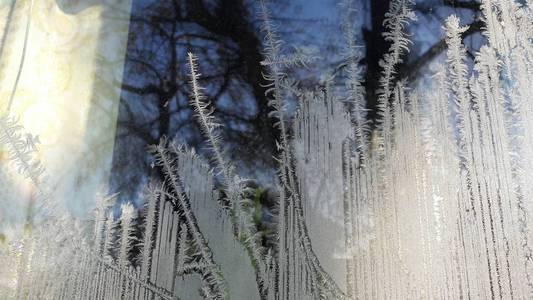 美丽的特写镜头冬季窗窗包覆盖闪亮的冰霜图案。冷冻窗玻璃, 窗外的晨霜画