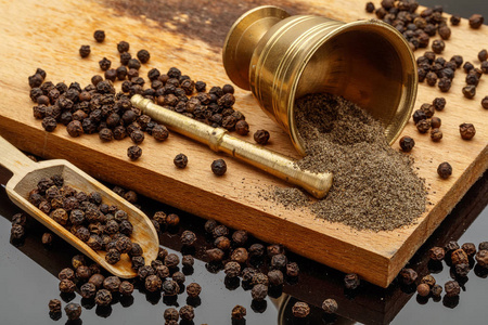 厨师黑胡椒黑胡椒在木切割板上研磨黑胡椒照片