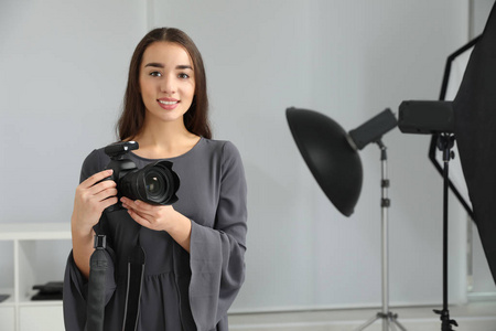 摄影棚里有专业相机的年轻女人。 文本空间