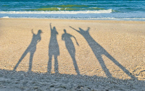 四个人的影子在海天云的背景下上岸，夏日阳光，周末假期，波浪泡沫