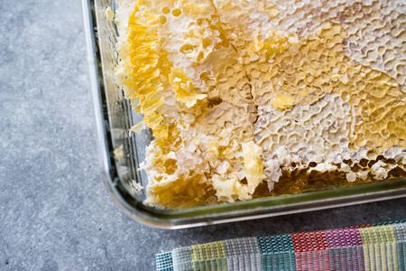 在玻璃碗中加入蜂蜜的新鲜蜂窝碎片。有机食品。
