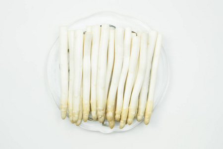 一组白色芦笋放置在一个带有孤立背景的盘子上