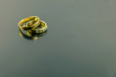 两个结婚戒指被隔离在黑暗的背景上
