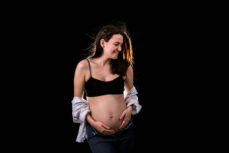 怀孕妇女肖像的黑色背景概念怀孕和预期的孩子