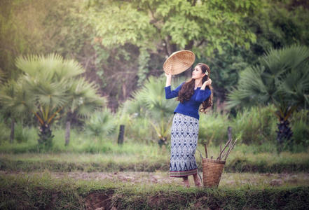 妇女的肖像,手拿帽子和篮子,以收获农业农村生活年轻女孩服饰部落照片