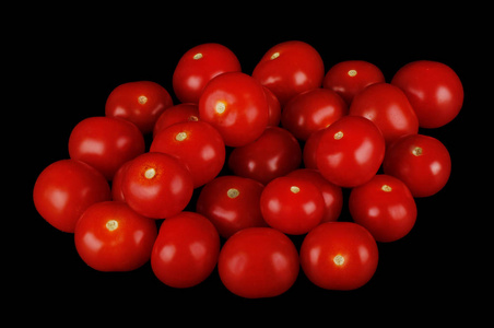 黑色背景上的一堆新鲜成熟的西红柿