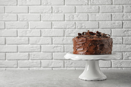 站在砖墙附近的桌子上，放着美味的自制巧克力蛋糕。 文本空间
