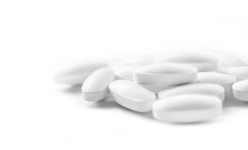 白色药物片堆选择性聚焦于白色背景照片
