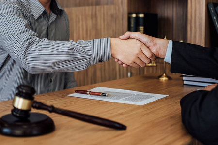 经过良好的合作，商人握手，男性律师在讨论了良好的合同约定和合作理念后握手。