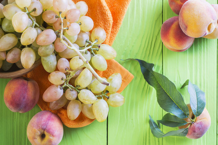 新鲜成熟的桃子和葡萄在木制背景的顶部视图。 健康的食物背景。