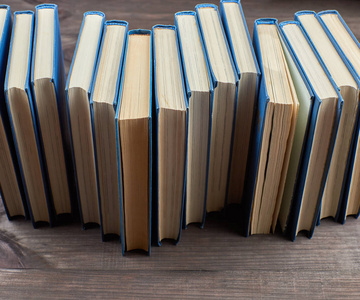 棕色木桌上一叠蓝色封面的书，俯视图
