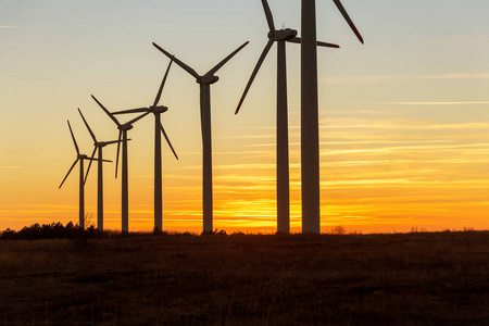 杜斯克的风力涡轮机。风景日落与风车。更新电源..风力涡轮机在山上提供清洁能源的新技术，在天空中看到五彩缤纷的晚霞