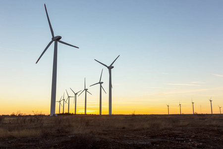 杜斯克的风力涡轮机。风景日落与风车。更新电源..风力涡轮机在山上提供清洁能源的新技术，在天空中看到五彩缤纷的晚霞