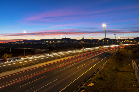 高速公路在黄昏时，双向交通与灯光小径。