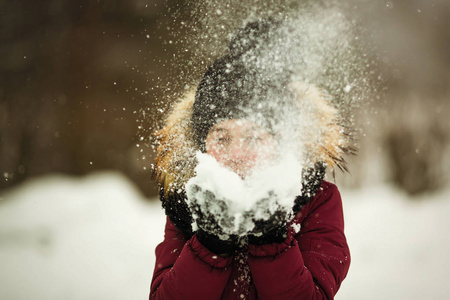 情感女孩在冬天在户外玩雪。
