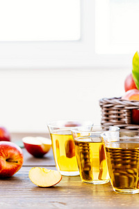 苹果汁在玻璃杯中，红苹果在篮子里，健康的食物和饮酒的概念