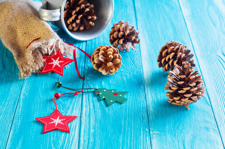 圣诞背景。 冷杉锥礼品袋和红色木星在蓝色木制背景与复制空间。 圣诞节或新年卡片模板。