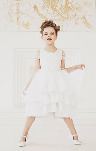 美丽的小女孩，金发，穿着白色的裙子。