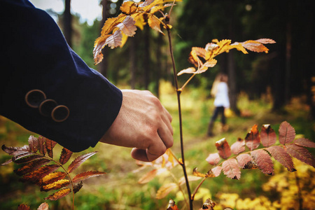 男人和女人在秋天的森林里散步。闭合。