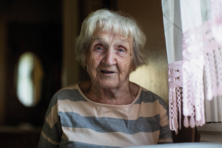 一位退休的俄罗斯妇女在家里的桌子上的肖像。