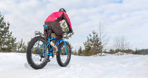 冬天,胖子骑自行车在雪地里骑自行车. 胖自行车.照片