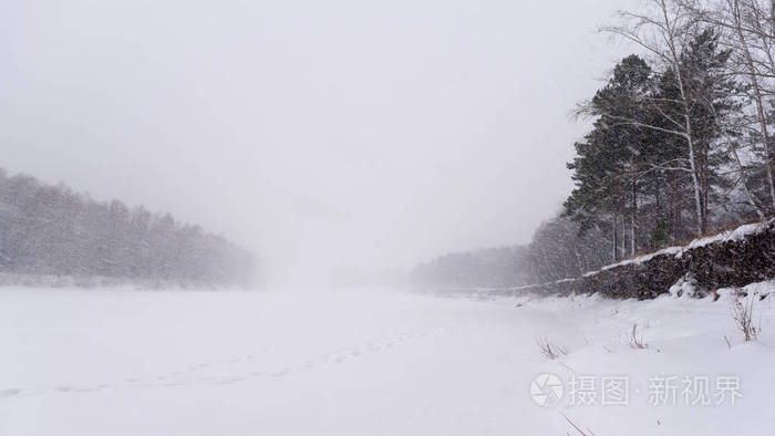 冬天，一场大雪覆盖了河冰上的铁轨，两岸中间有树木和悬崖。