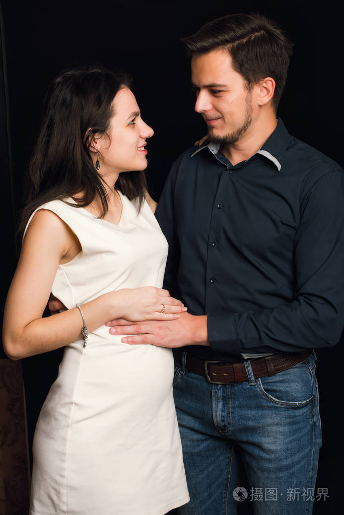 快乐的白种人夫妇等待孩子的出生.男人拥抱怀孕的女孩