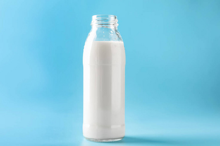 彩色背景上的美味牛奶玻璃瓶