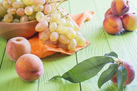 新鲜的成熟桃子和葡萄在木制背景。健康食品背景。
