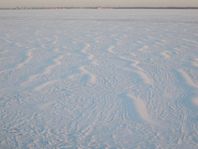 日落时分，冰冻的河流上的雪面