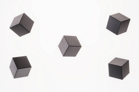 黑色的木制立方体形状是浮动的。 创造性逻辑思维的概念。 抽象几何真实浮动木立方体。