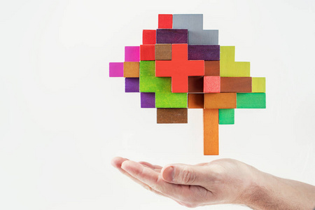 人类的手握着抽象的大脑。 人脑是由多种颜色的木块组成的。