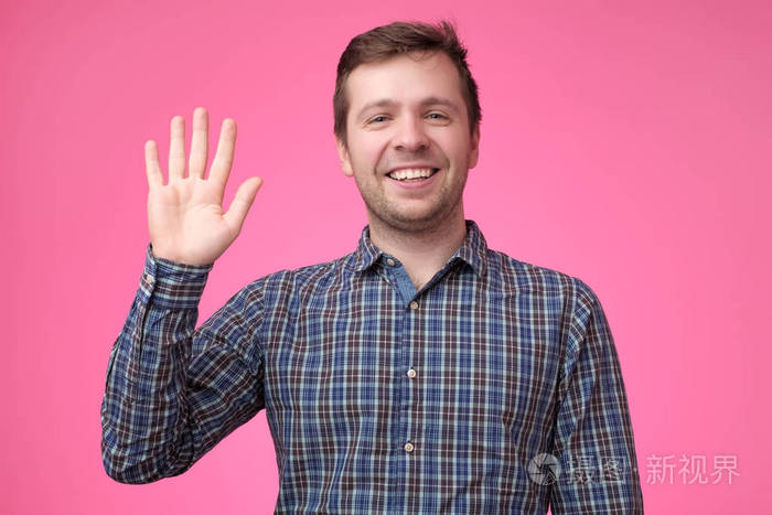 身穿格子蓝色衬衫的男子挥手致意照片-正版商用图片17v29w-摄图新视界
