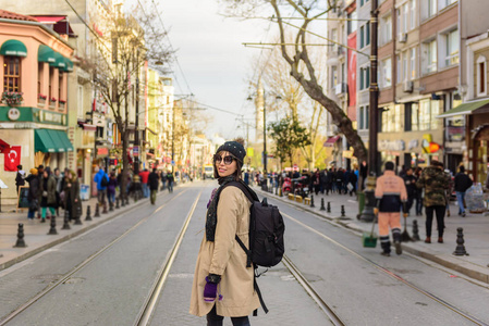 一位美丽的女游客背着背包在伊斯坦布尔拥挤的公路上散步