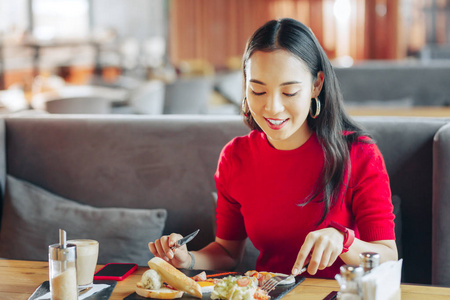 年轻的女商人在餐馆吃饭时享受休息照片