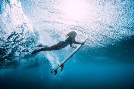 冲浪女人在水下用波浪潜水。