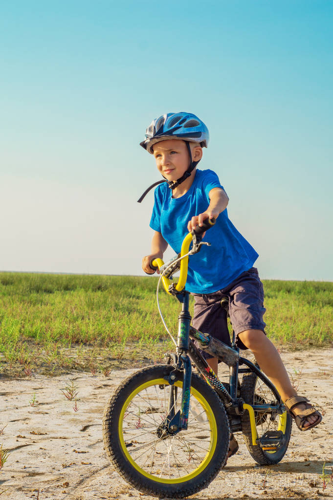 男孩骑自行车穿过农村.