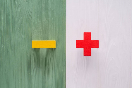 对立面的概念正负平躺. 木制背景上的木制人物.