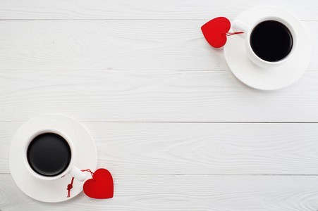 情人节背景与复制空间。 几个白色的杯子，咖啡和红色的心在白色的木制桌子顶部的视图。 浪漫的咖啡平躺。 浪漫早餐和两杯咖啡。